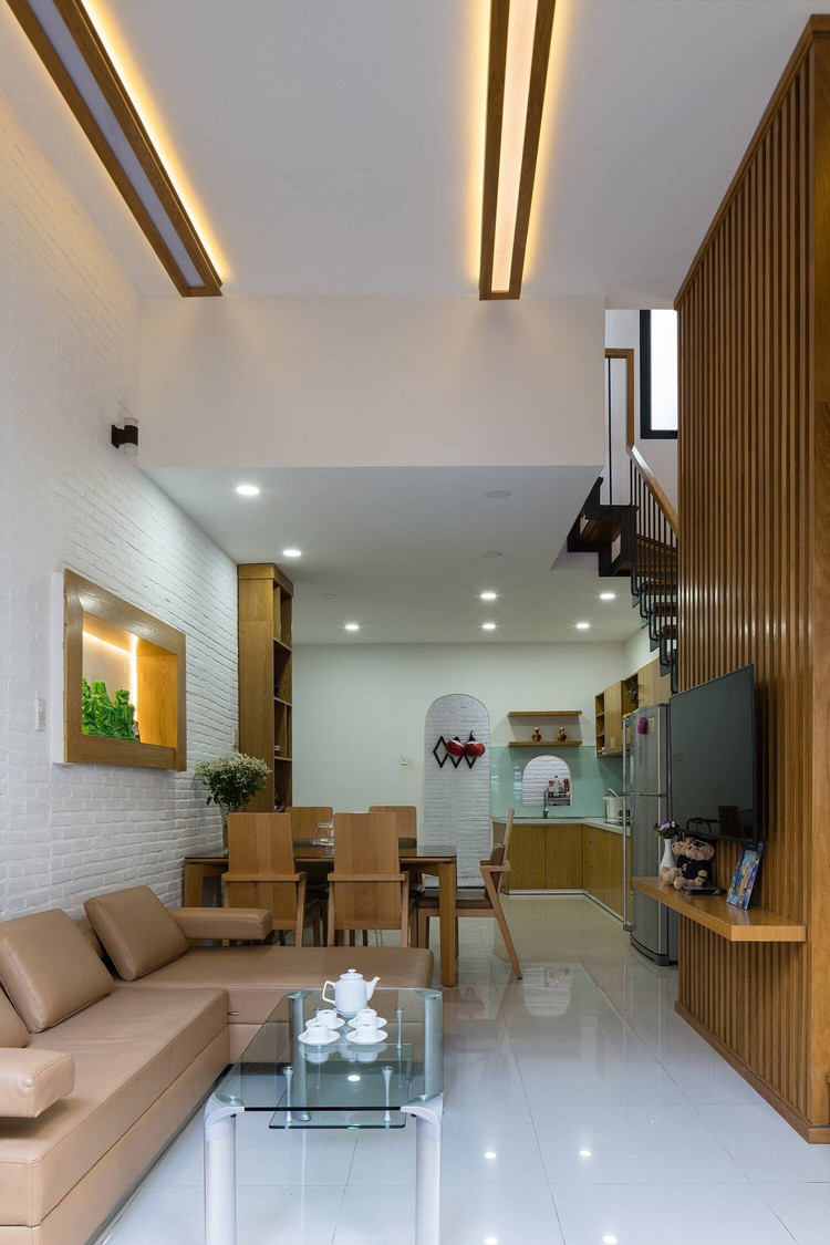 Tường, trần và sàn nhà sử dụng màu trắng sáng sủa kết hợp với đồ nội thất chất liệu gỗ được thiết kế đồng bộ từ vách ngăn, tay vịn cầu thang, cửa, kệ tủ bếp,...Ảnh: Quang Dam nha-pho7.jpg